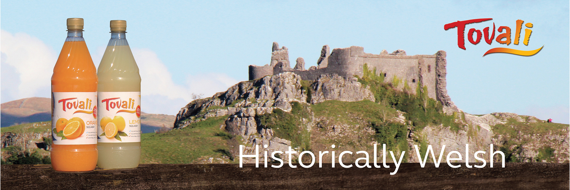 Tovali Squash and Cordial bottles, pictured in front of Carreg Cennen Castle