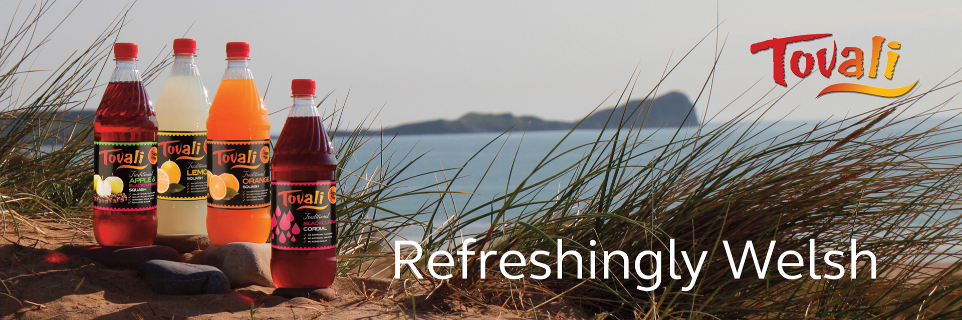 Tovali Squash and Cordial bottles, pictured in front of Rhossili